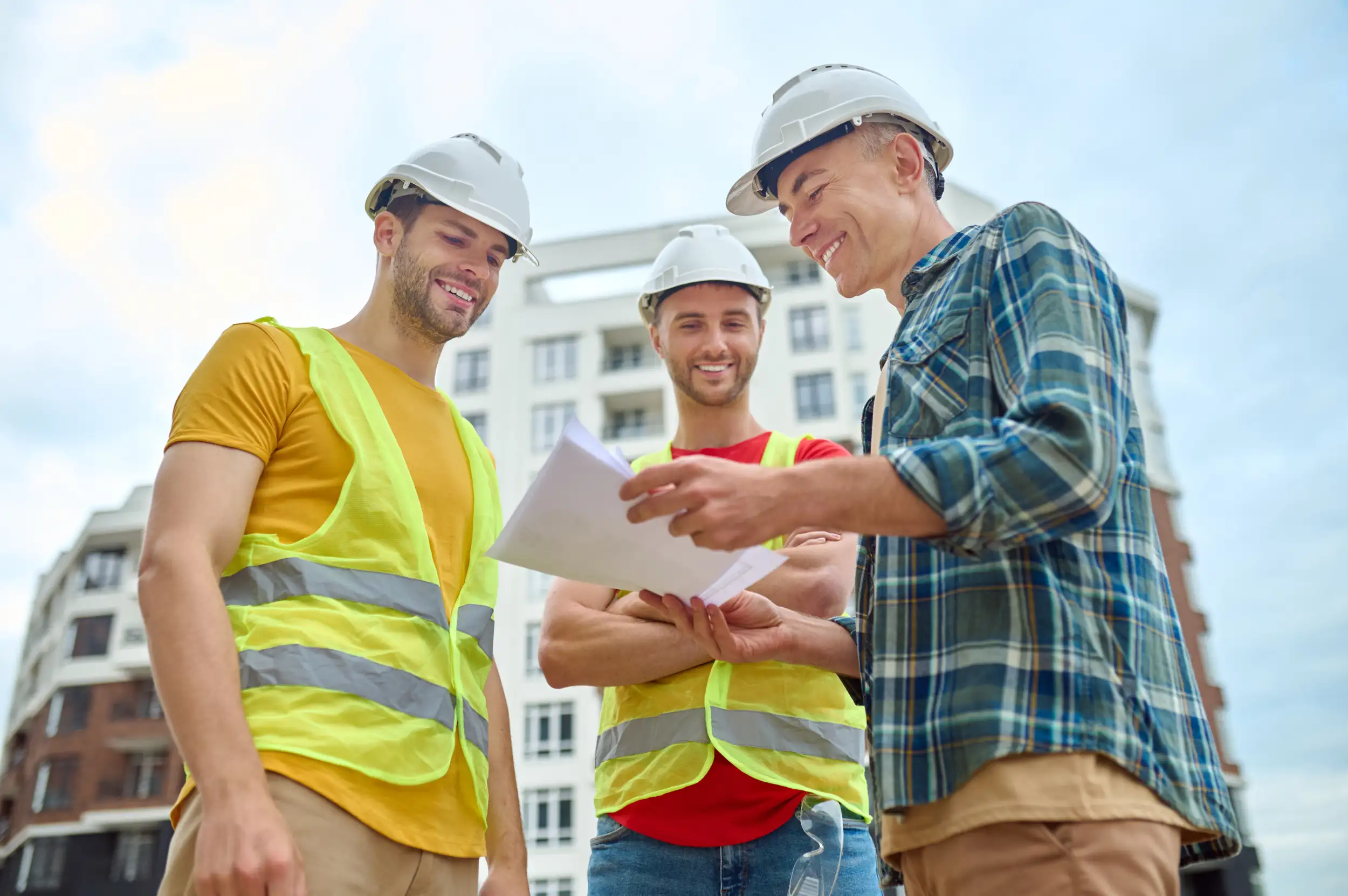 Three men discussing the plan of the new house.